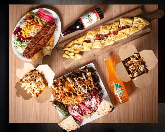A full Baba Döner spread with kebab, pide, döner boxes and drinks